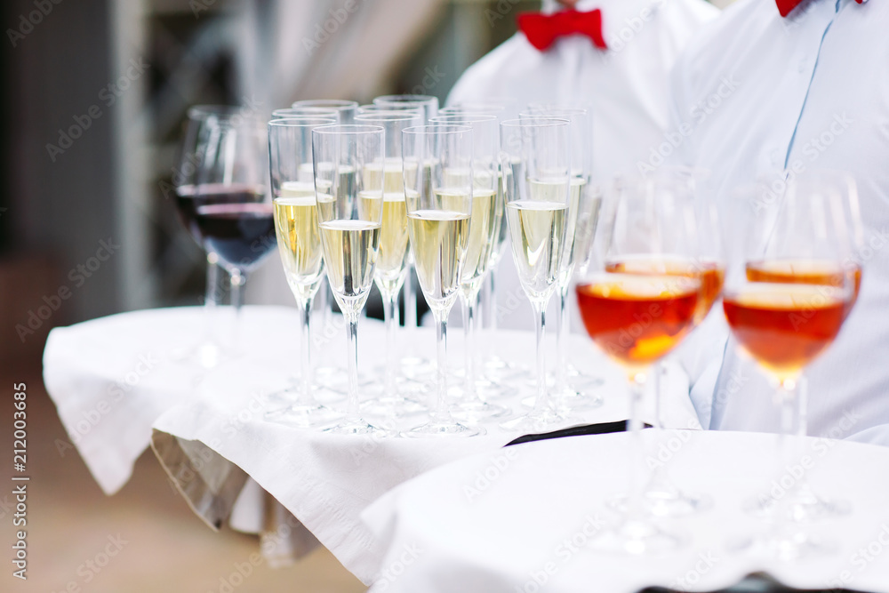 The waiters greet guests with alcoholic drinks. Champagne, red wine, white wine on trays. The waiters greet guests with alcoholic drinks. Champagne, red wine, white wine on trays.