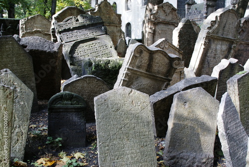 Historic old Jewish cemetery with rock tombs in Prague and broken monuments by the passage of time photo