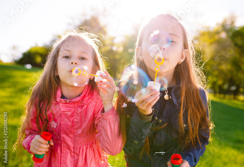 Girls play with soap bubbles.