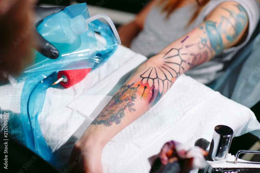 Professional tattoo artist makes a tattoo on a young girl's hand. Professional tattoo artist makes a tattoo on a young girl's hand.