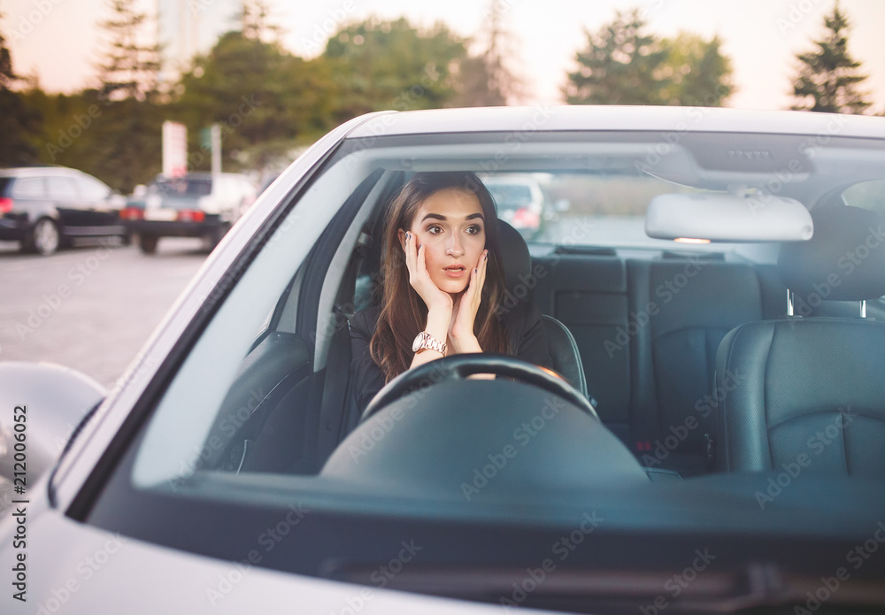 The girl in the car is in a traffic jam. The girl in the car is in a traffic jam.