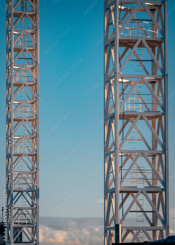 Two crane towers with sky background