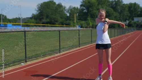 Teen girl athlete exercising on a running track photo