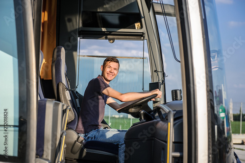 Young handsome man at the wheel of bus