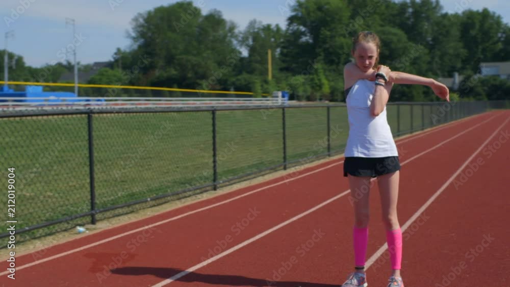 Teen girl athlete exercising on a running track Teen girl athlete exercising on a running track