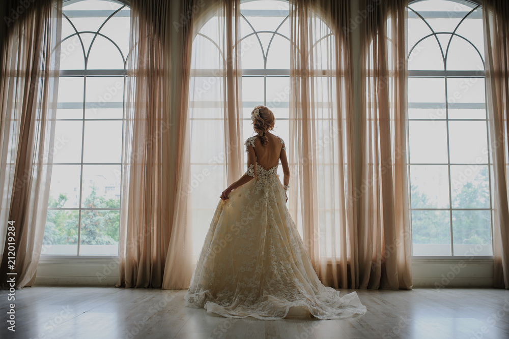 Bride in long white dress at the window Bride in long white dress at the window