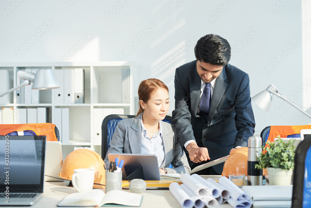 Coworkers discussing data on digital tablet Coworkers discussing data on digital tablet