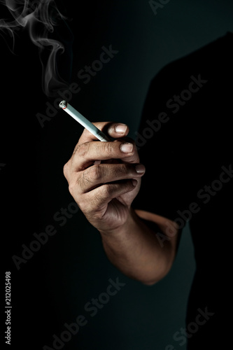 male hand holding a cigarette. close up man smoking.