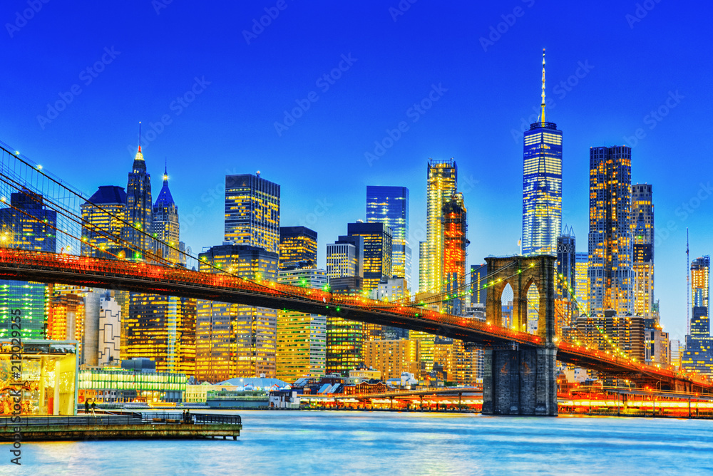 Obraz premium New York night view of the Lower Manhattan and the Brooklyn Bridge across the East River.