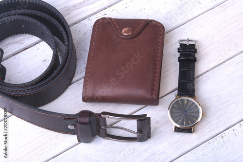 Men's accessories for business and rekreation. Leather belt, wallet, watch and smoking pipe on wood background.. Top view composition.