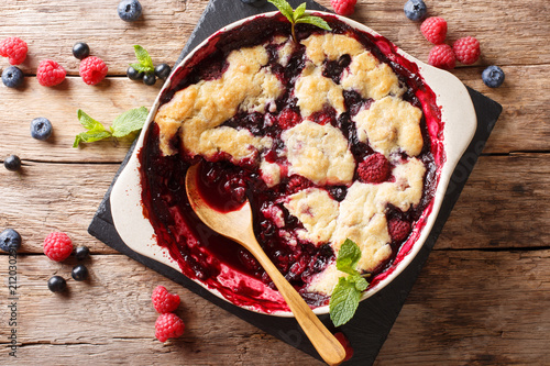 English cuisine: berry cobbler is decorated with mint closeup.  horizontal top view photo