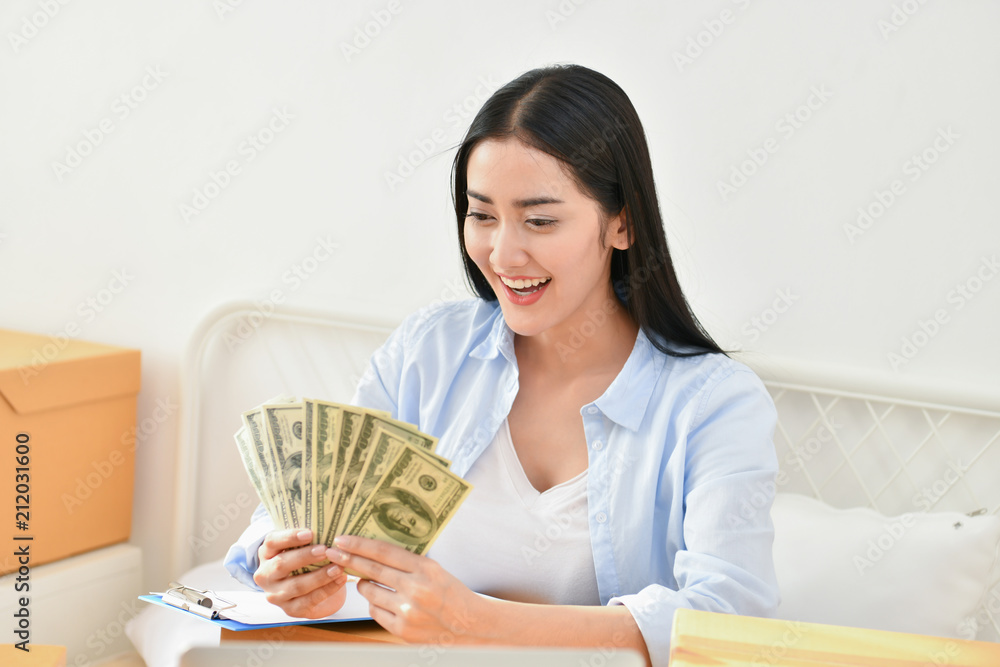 Sme business concept. Young people are packing their packages.Delivery business Small and Medium Enterprise (SMEs). Young Owner Start up for Business Online. Beautiful girls are counting money. Sme business concept. Young people are packing their packages.Delivery business Small and Medium Enterprise (SMEs). Young Owner Start up for Business Online. Beautiful girls are counting money.