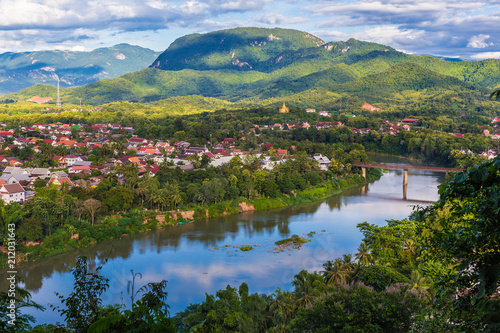 View of Luang Prabang and Nam Khan river in Laos with beautiful sunset light bathing the mountains photo