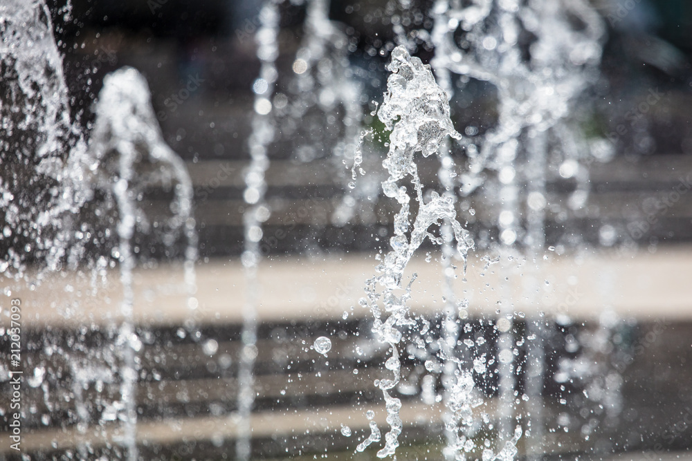 Splashing water from a fountain in the park as a background Splashing water from a fountain in the park as a background