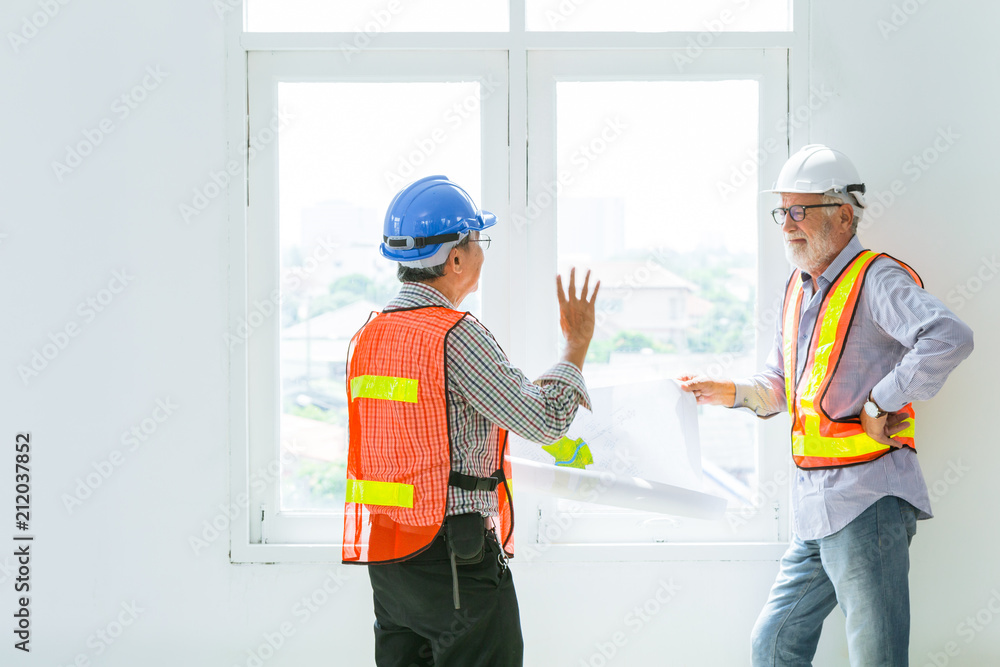 mix race senior construction engineers worker talking together about future of design with blueprint