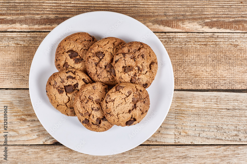 oatmeal cookies with chocolate slices in a white plate on a wooden background oatmeal cookies with chocolate slices in a white plate on a wooden background