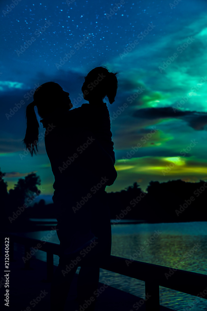 Silhouette of mother and daughter enjoying view.