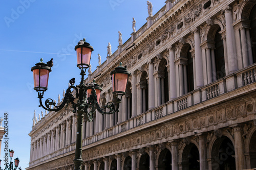 Lantern in building background on piazza San Marco in Italy. Concept of trip to Venice and architecture. photo