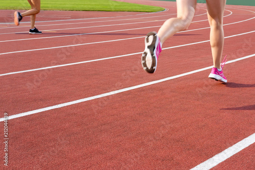 Athletics people running on the track field. Closeup of legs of a track runners