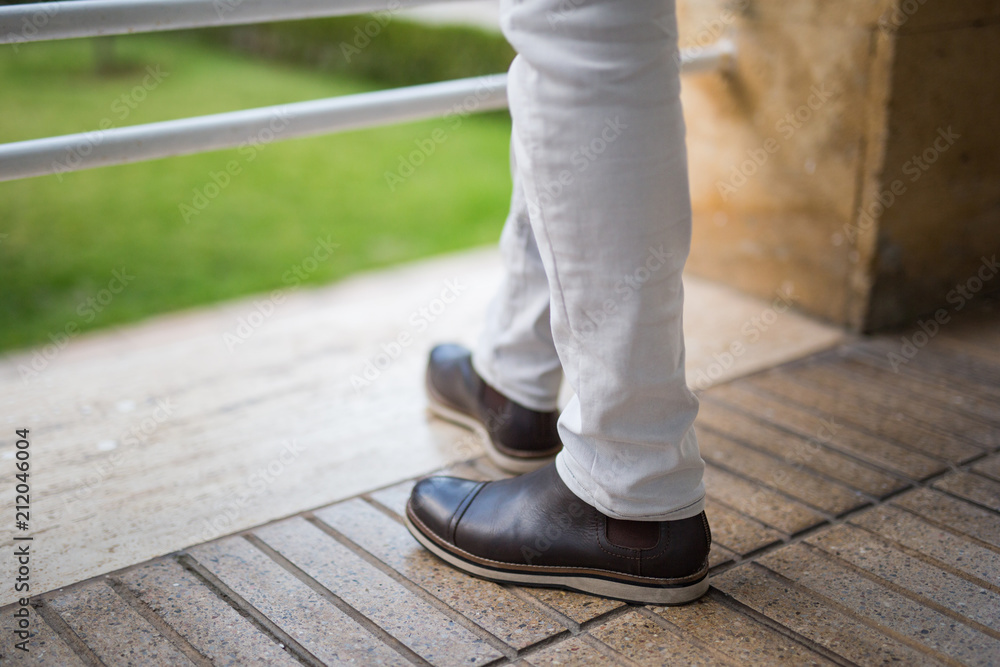 low section of a man standing on balcony low section of a man standing on balcony