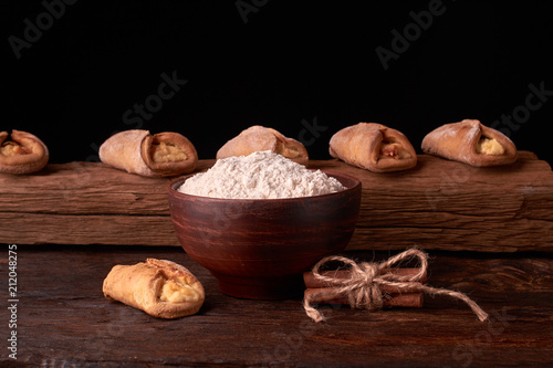 Cottage cheese cookies and little flour on oak wooden background. Macro, close up. Selective focus
