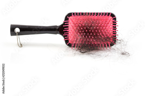 Pile of women s hair loss problem  hairs fall with pink brush on white background.