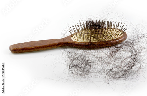 Pile of women's hair loss problem, hairs fall with pink brush on white background.