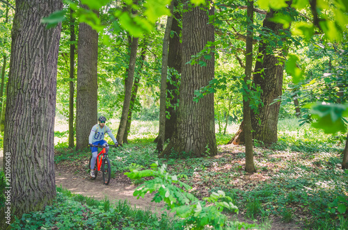 Cyclist in helmet on orange bike riding in park