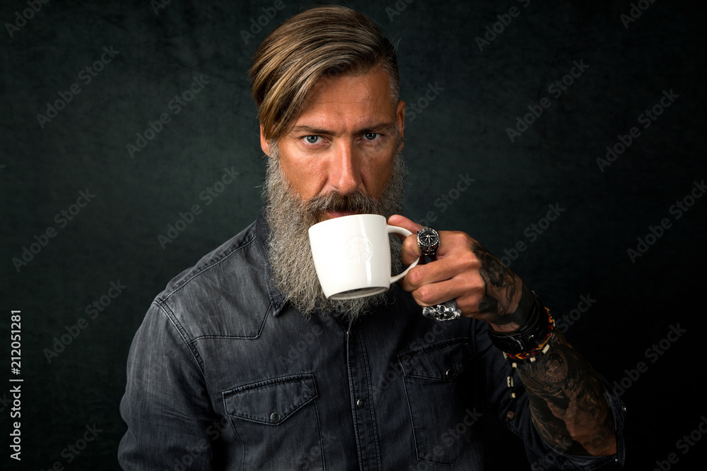 Porträt eines bärtigen Mannes mit einem Tasse Kaffee, vor dunklem Hintergrund Porträt eines bärtigen Mannes mit einem Tasse Kaffee, vor dunklem Hintergrund