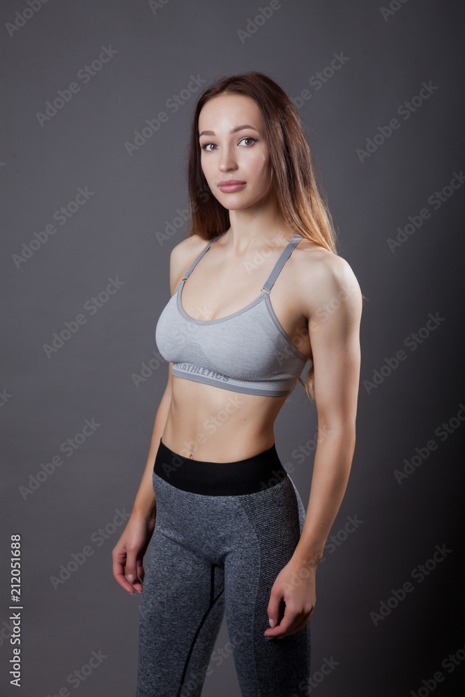 fitness trainer relaxed posing on grey background fitness trainer relaxed posing on grey background