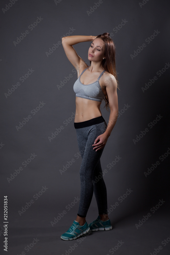 fitness trainer relaxed posing on grey background fitness trainer relaxed posing on grey background