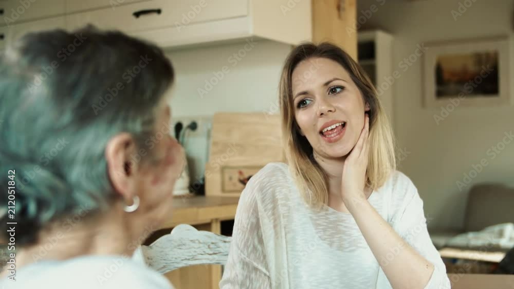 A young beautiful woman talking to grandmother at home. A young beautiful woman talking to grandmother at home.