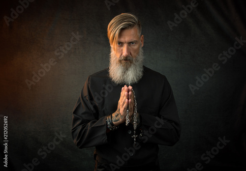 Portrait eines heiligen Priesters vor einem dunklen Hintergrund photo