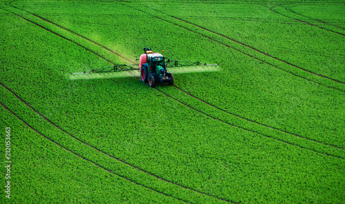 фотографія Farm machinery spraying insecticide to the green field, agricultural natural sea