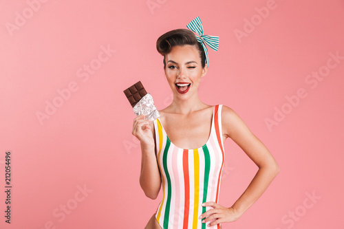 Pin up woman isolated eating chocolate.