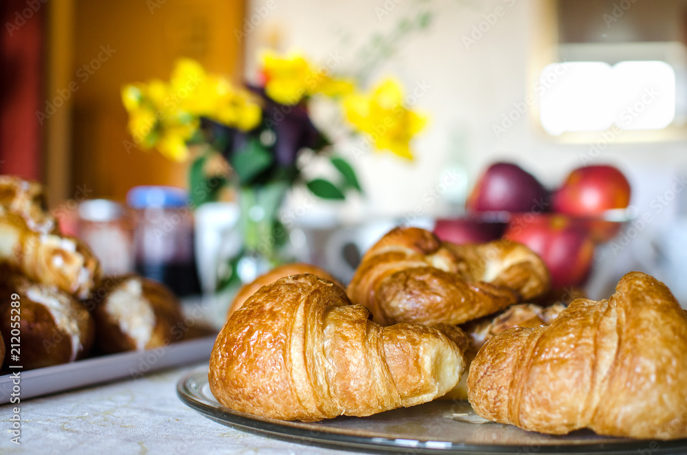 Fresh french croissants at the breakfast table with flowers and fruits. Traditional. Fresh french croissants at the breakfast table with flowers and fruits. Traditional.