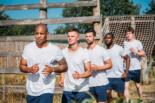 Fotografi Portrait of multicultural young soldiers running on range