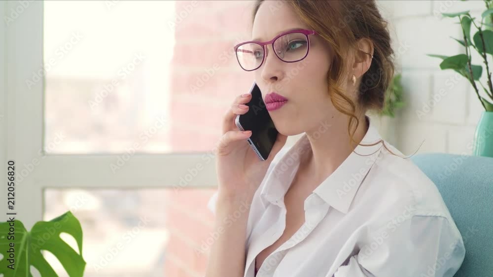 Happy woman talking on mobile phone in living room at home 4k. Happy woman talking on mobile phone in living room at home 4k.