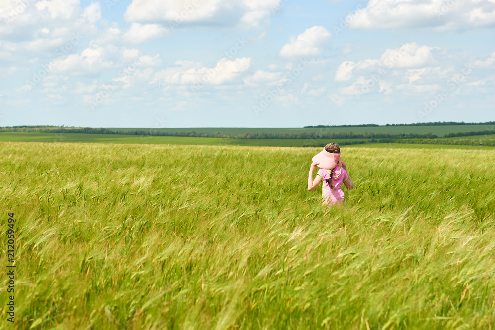 child walking through the wheat field, bright sun, beautiful summer landscape