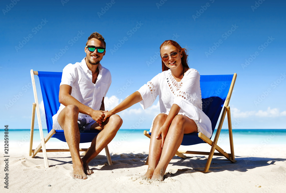 Summer trip on beach. Two lovers and sea landscape with blue sky. Free space for your text. 