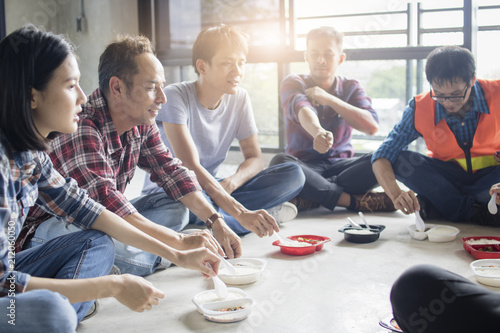 Group of happy engineers and workers enjoy eating food and relax by talking and corpora ting. Teamwork and team concept