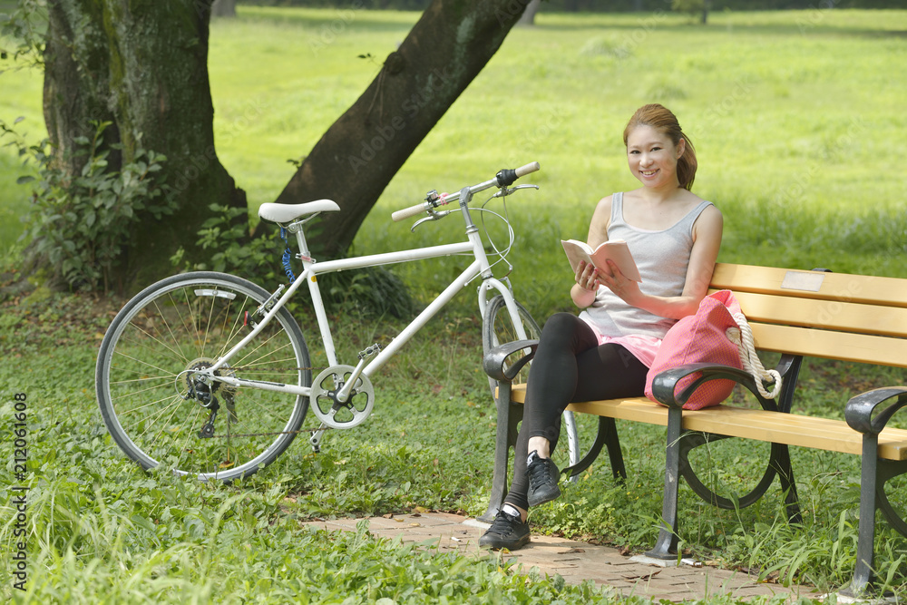Obraz premium 公園で本を読む女性