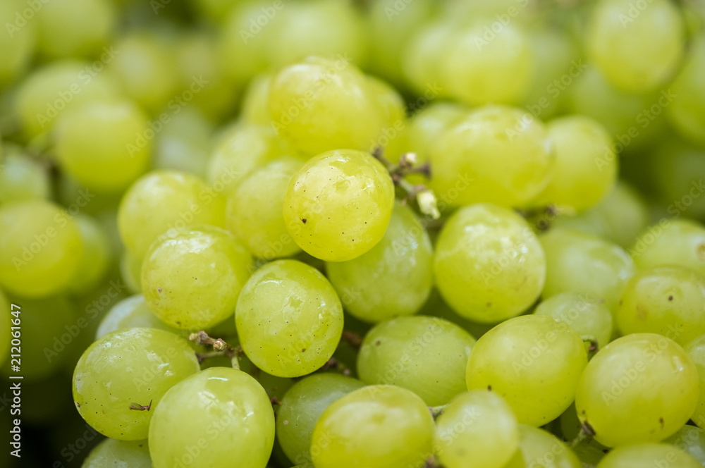 Macro shot of new harvest green-yellow grapes for sale at local farmers market Macro shot of new harvest green-yellow grapes for sale at local farmers market