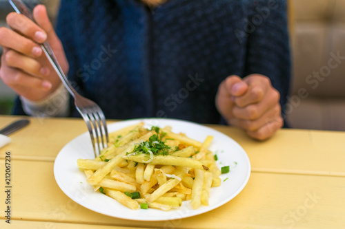 Eating French fries in a cafe.