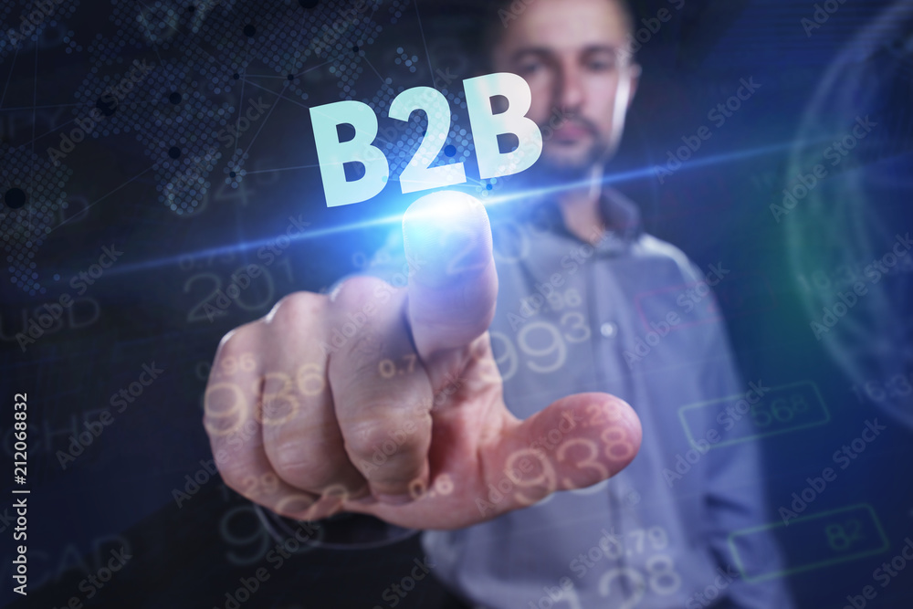 The concept of business, technology, the Internet and the network. A young entrepreneur working on a virtual screen of the future and sees the inscription: B2B The concept of business, technology, the Internet and the network. A young entrepreneur working on a virtual screen of the future and sees the inscription: B2B