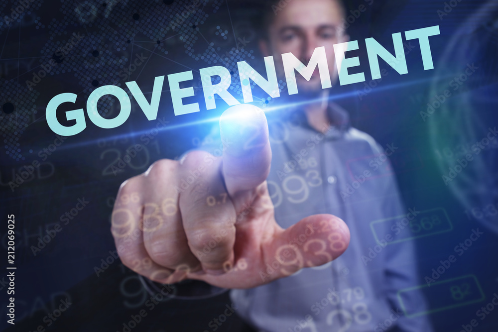 The concept of business, technology, the Internet and the network. A young entrepreneur working on a virtual screen of the future and sees the inscription: Government The concept of business, technology, the Internet and the network. A young entrepreneur working on a virtual screen of the future and sees the inscription: Government