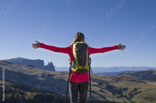 Woman cheering from the summit of a mountain