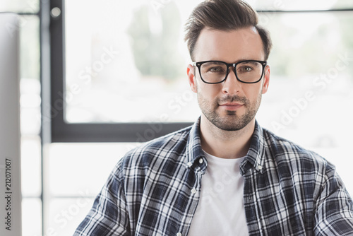 Portrait of handsome young man in eyeglasses looking at camera