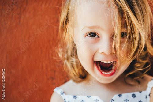 Portrait of an emotional girl on a red background.