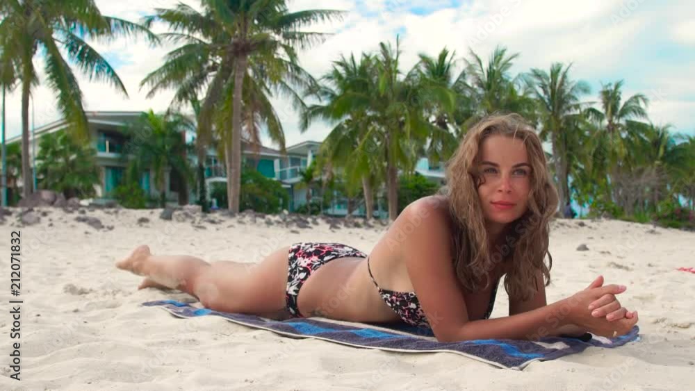 sunbathing-woman-lying-on-towel-on-summer-beach-on-luxury-villa